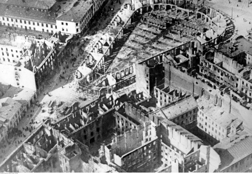 Kadr z filmu „Feuertaufe” przedstawiający zniszczony bombardowaniami „Gościnny Dwór” na placu Za Żelazną Bramą, 1939-1940, fot. Tobis, Narodowe Archiwum Cyfrowe: 2-11235